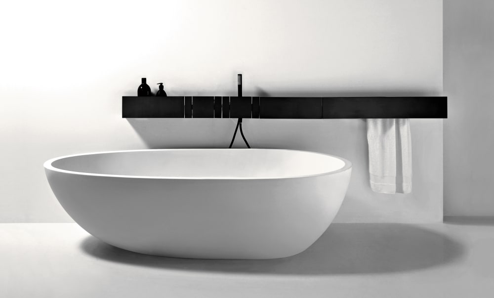Minimalist freestanding tub with wall-mounted black fixture bar